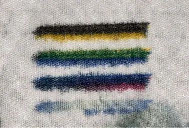 A spray test on a lint-free cloth showing solid, unbroken bands of black, yellow, green, blue and magenta ink