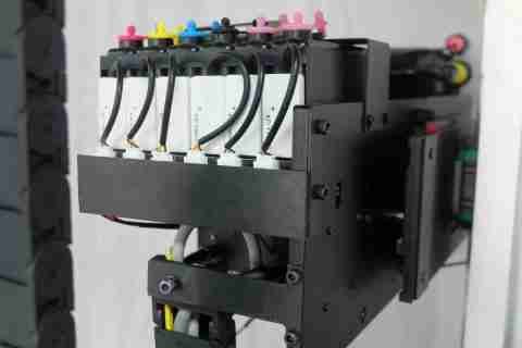 The five color-coded ink tanks on the printer's carriage, each feeding the print head