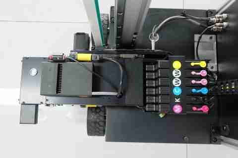 The print head carriage with the color-coded ink lines feeding into it