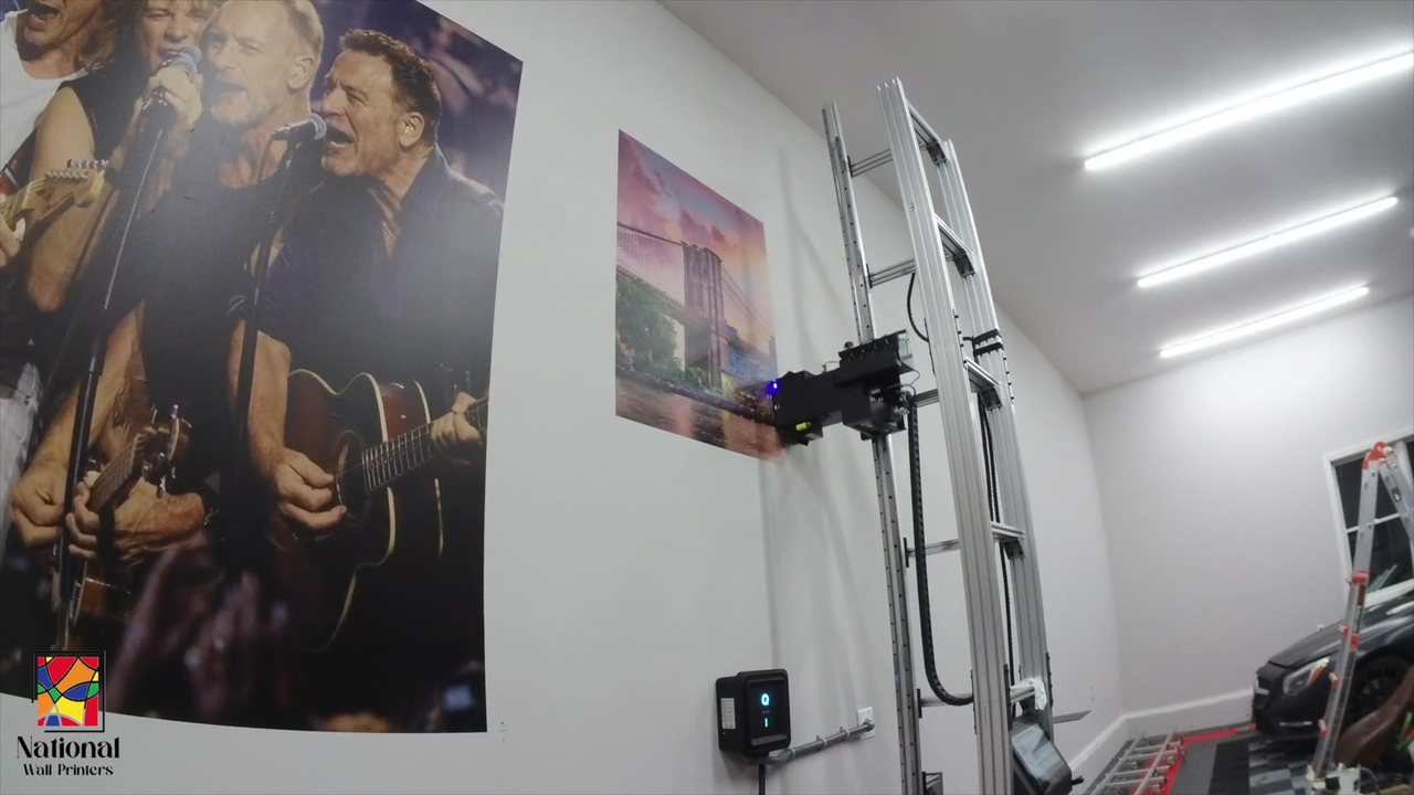 A vertical wall printer beside finished full-color murals in the Bay Shore demo center